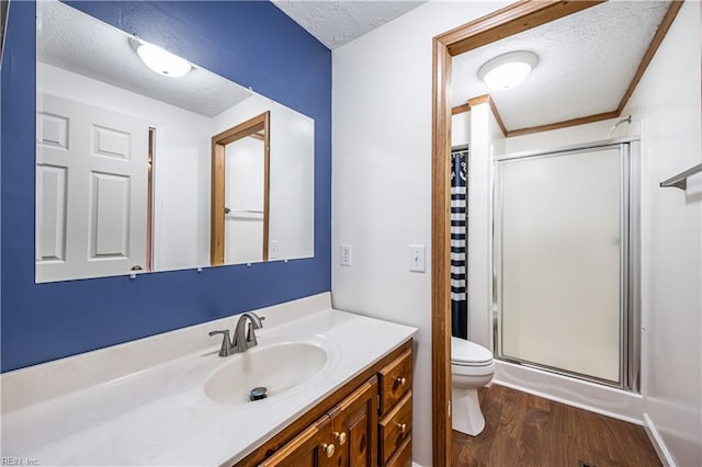 full bath featuring a textured ceiling, curtained shower, toilet, wood finished floors, and vanity