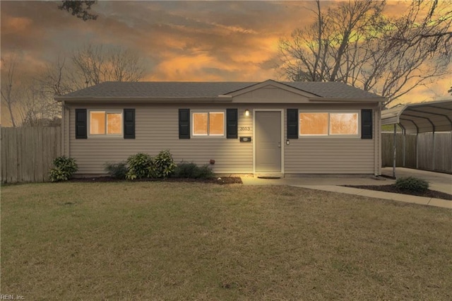 single story home with a front yard, concrete driveway, fence, and a detached carport