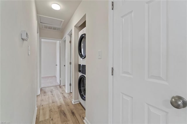 laundry room with laundry area, light wood finished floors, baseboards, visible vents, and stacked washer and clothes dryer