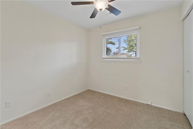 empty room featuring light carpet, baseboards, and a ceiling fan