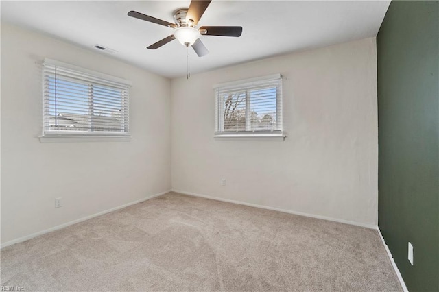 unfurnished room featuring carpet floors, visible vents, ceiling fan, and baseboards