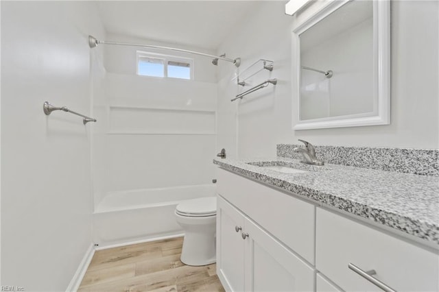 bathroom featuring toilet,  shower combination, wood finished floors, and vanity