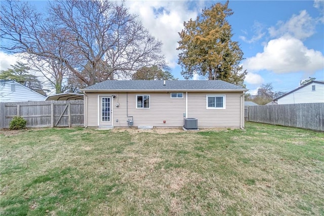 rear view of property with central air condition unit, a fenced backyard, and a lawn