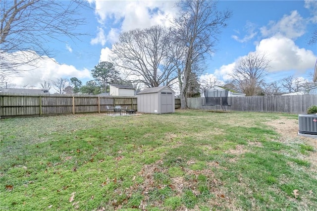 view of yard featuring central AC unit, a shed, an outdoor structure, and a fenced backyard