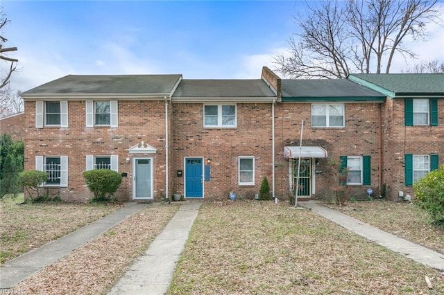 view of property with a front yard and brick siding