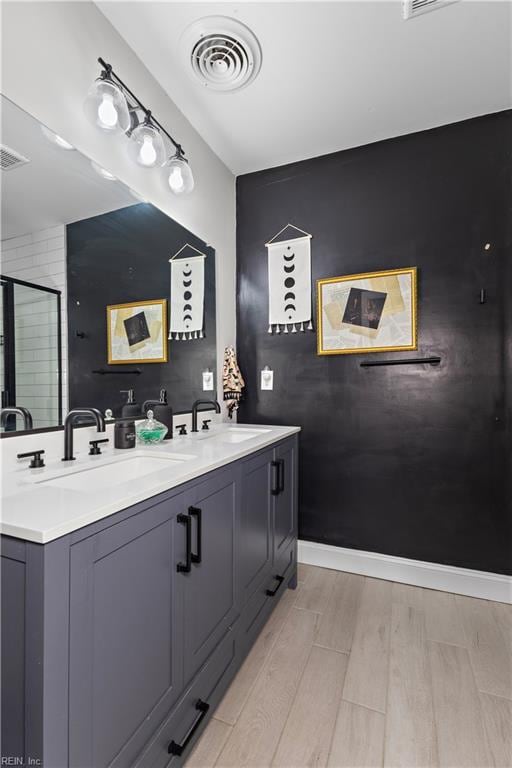 bathroom with a sink, visible vents, and a shower stall