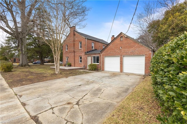 traditional home with an attached garage, concrete driveway, and brick siding