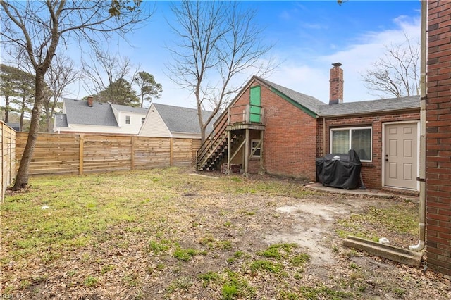 view of yard with a fenced backyard and stairs