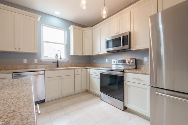 kitchen featuring light tile patterned floors, stainless steel appliances, a sink, light countertops, and pendant lighting