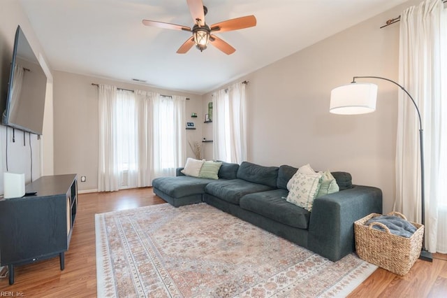 living area featuring ceiling fan, vaulted ceiling, wood finished floors, and visible vents