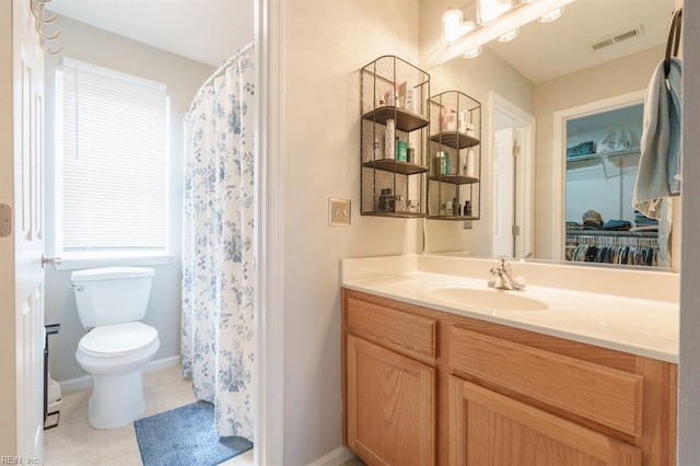 bathroom featuring visible vents, toilet, vanity, tile patterned flooring, and baseboards