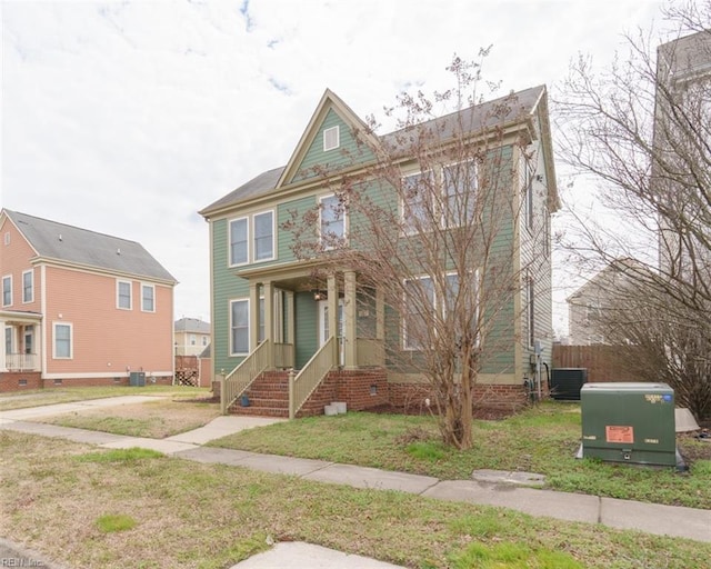 view of front of property with fence, a front lawn, and central AC