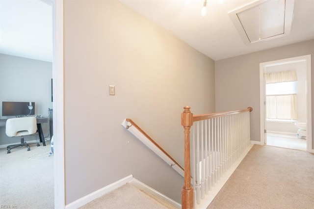 stairs with attic access, carpet floors, and baseboards