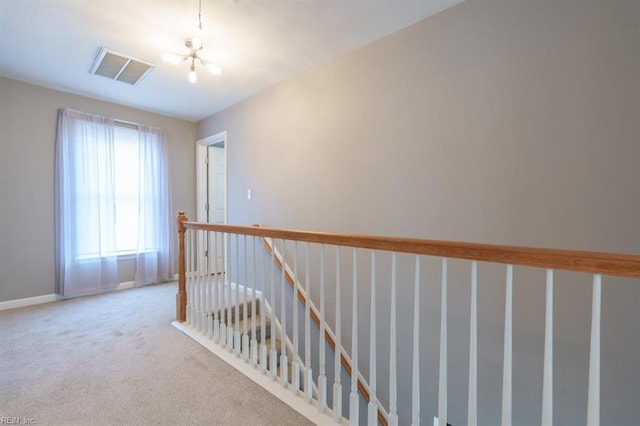 corridor with an upstairs landing, carpet flooring, visible vents, and baseboards