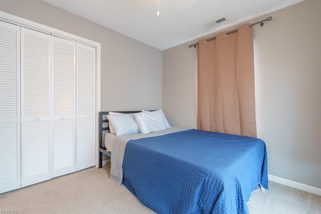 bedroom with a closet, visible vents, baseboards, and carpet flooring