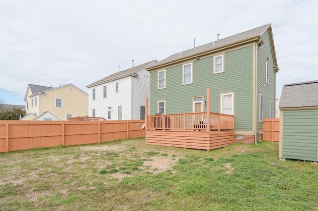 back of house with an outbuilding, a fenced backyard, a yard, and a wooden deck