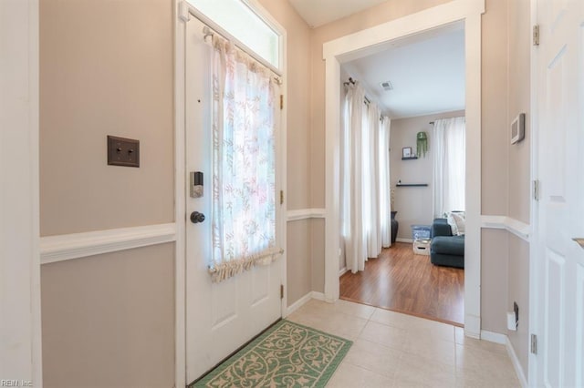 entryway with visible vents, baseboards, and light tile patterned floors