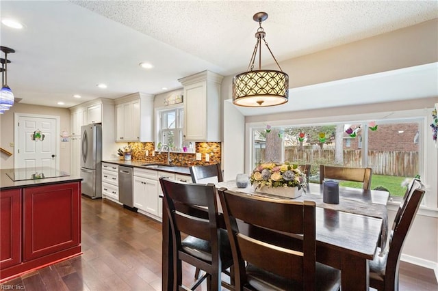 dining room with dark wood finished floors, a textured ceiling, and recessed lighting