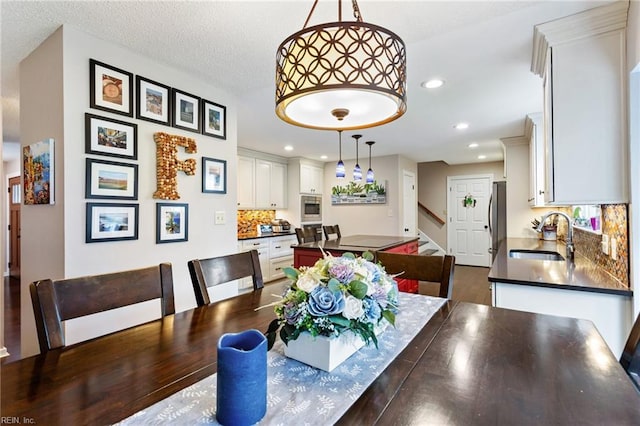 dining room featuring dark wood-style floors, stairs, a textured ceiling, and recessed lighting