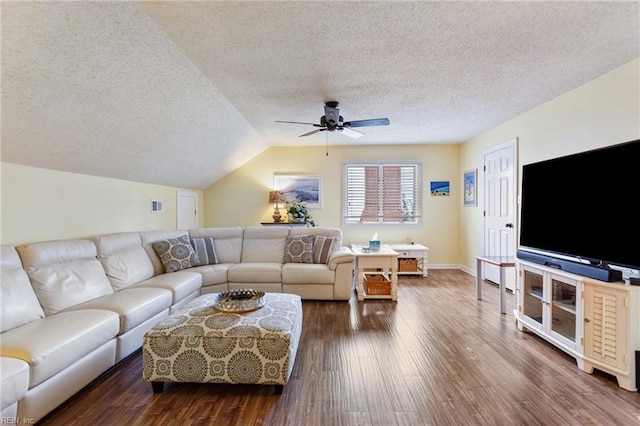 living room with dark wood-type flooring, vaulted ceiling, a textured ceiling, and ceiling fan