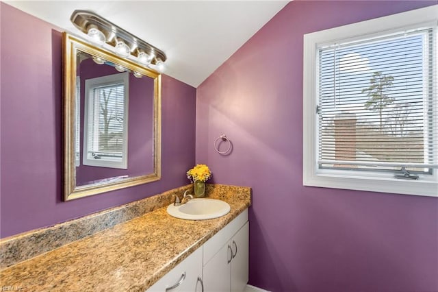 bathroom with vaulted ceiling and vanity