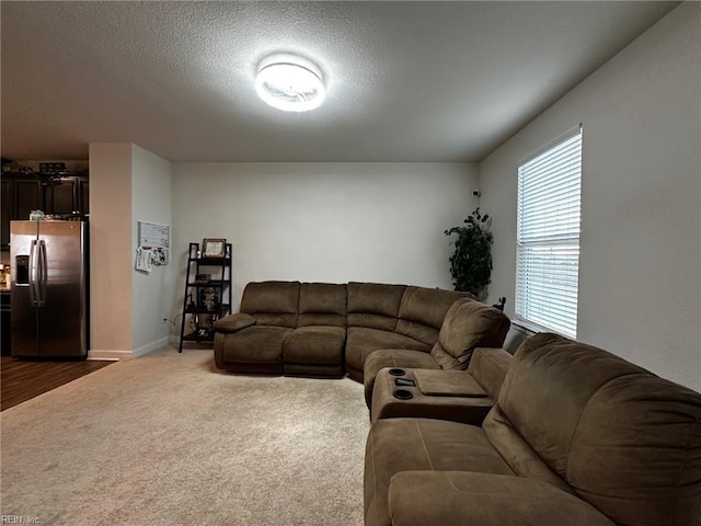 living room featuring dark colored carpet and a textured ceiling