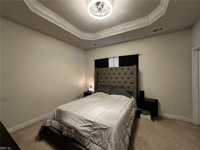 carpeted bedroom with a raised ceiling, visible vents, and baseboards