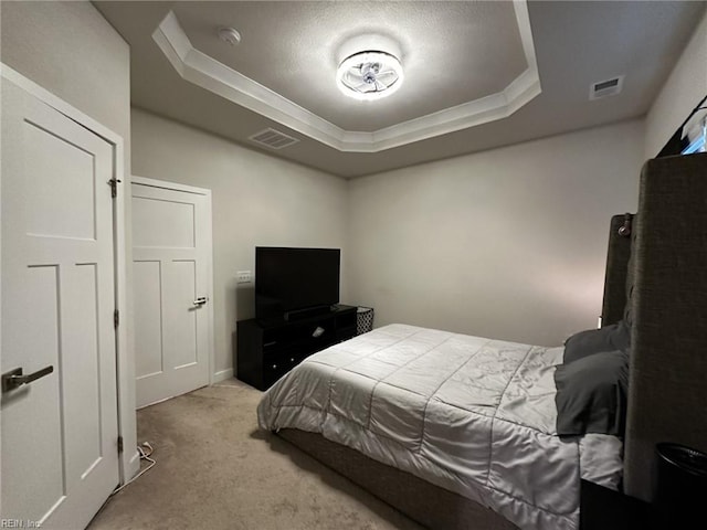 carpeted bedroom with visible vents and a raised ceiling