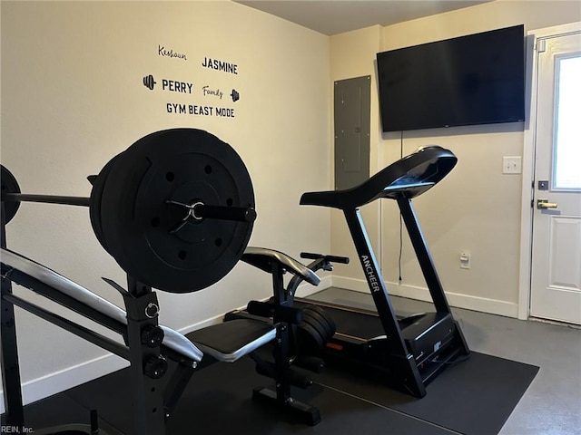 exercise area featuring electric panel and baseboards