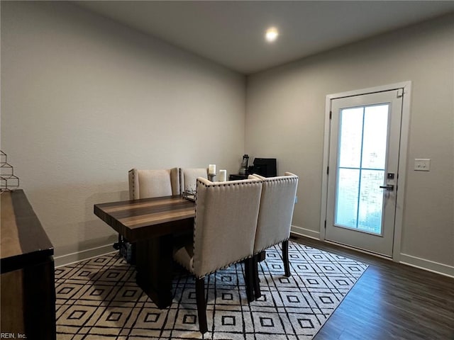 dining space featuring wood finished floors and baseboards