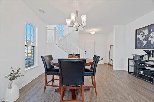 dining area featuring stairway, baseboards, and wood finished floors