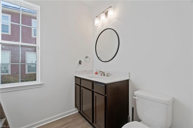 bathroom featuring vanity, wood finished floors, toilet, and baseboards