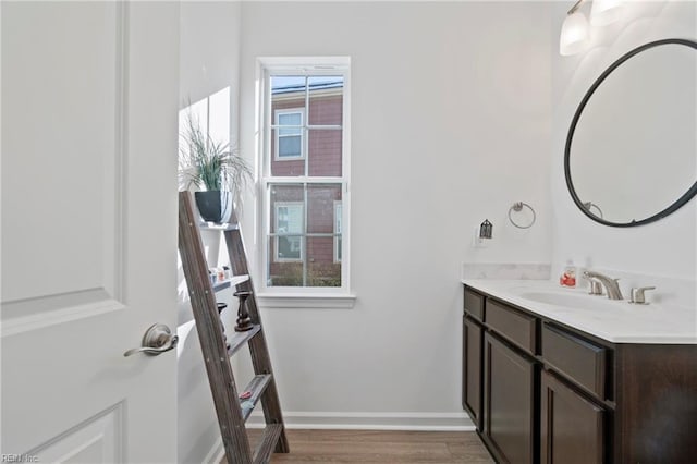 bathroom featuring vanity, baseboards, and wood finished floors