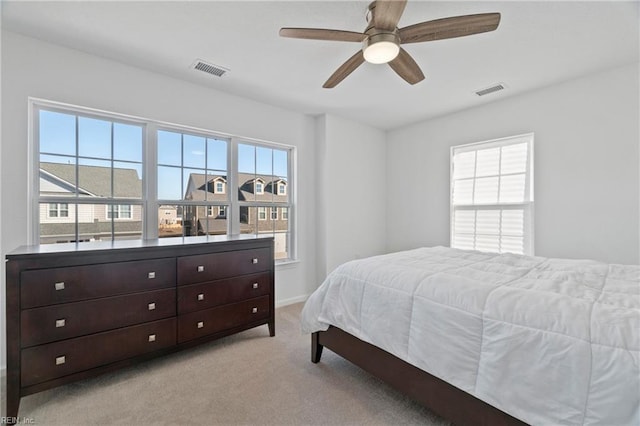 bedroom featuring light carpet, ceiling fan, and visible vents