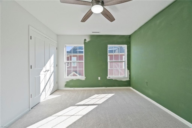 unfurnished bedroom with ceiling fan, visible vents, baseboards, and carpet flooring