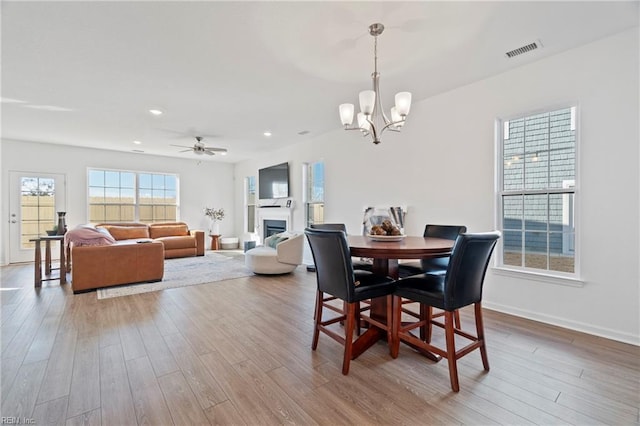 dining room featuring a fireplace, visible vents, wood finished floors, and recessed lighting