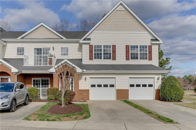 view of front of property featuring concrete driveway, brick siding, a balcony, and an attached garage