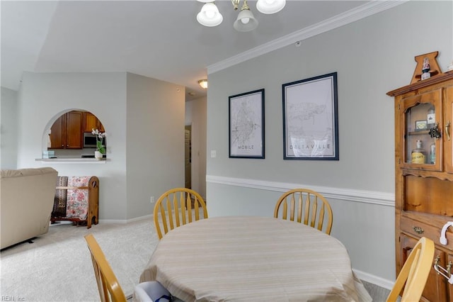 dining space featuring light carpet, ornamental molding, an inviting chandelier, and baseboards