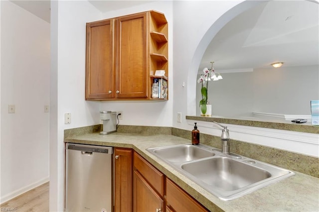 kitchen featuring brown cabinets, a sink, stainless steel dishwasher, and open shelves