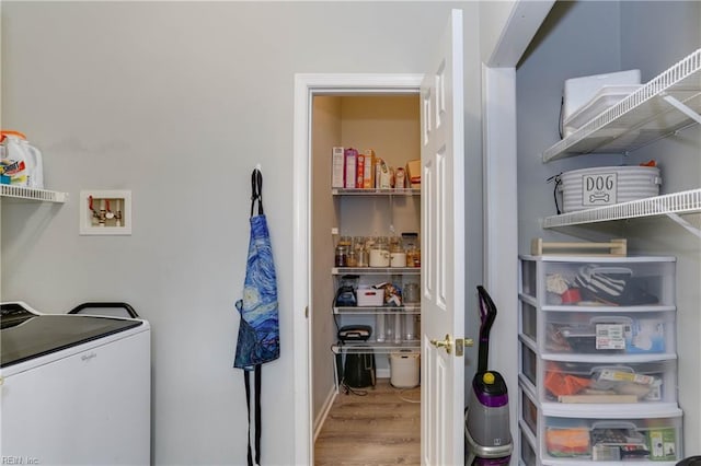 clothes washing area with washer / dryer, laundry area, and wood finished floors