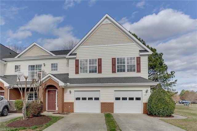 view of front facade with driveway, a shingled roof, a balcony, an attached garage, and brick siding