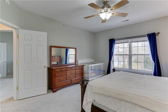 bedroom featuring a ceiling fan, light carpet, and visible vents