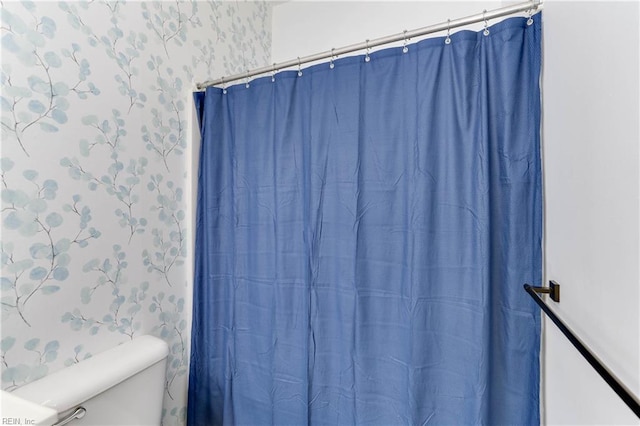 full bath with curtained shower, toilet, and wallpapered walls