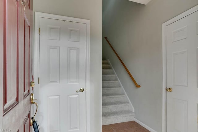 stairway with tile patterned flooring and baseboards