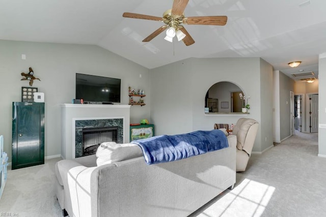 living room with light carpet, vaulted ceiling, a high end fireplace, and baseboards