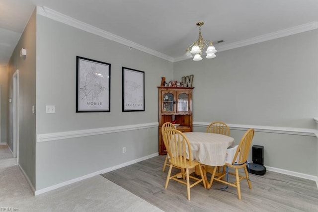 dining space featuring a chandelier, ornamental molding, and baseboards