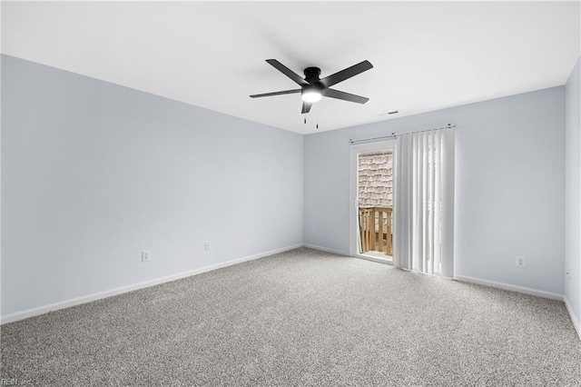 carpeted spare room with visible vents, baseboards, and a ceiling fan