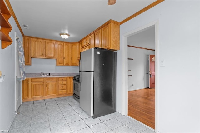 kitchen featuring light tile patterned floors, a sink, visible vents, ornamental molding, and appliances with stainless steel finishes