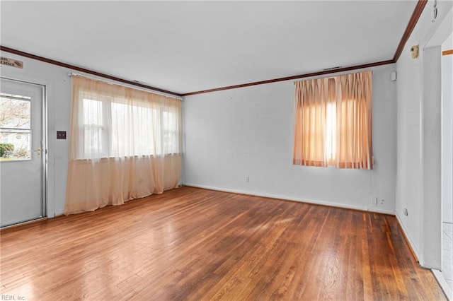 empty room featuring ornamental molding and wood finished floors