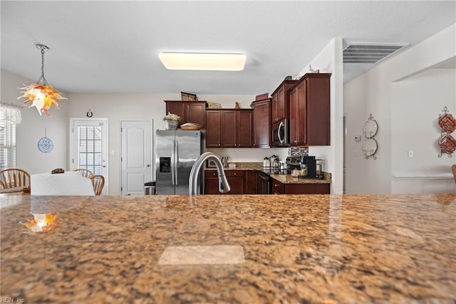 kitchen with visible vents, light stone counters, appliances with stainless steel finishes, pendant lighting, and a sink